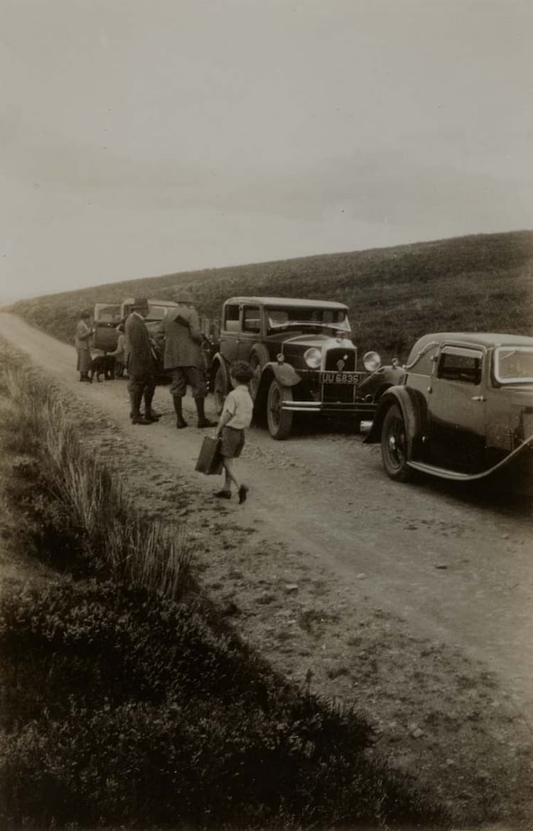 Members of the shooting party and Tom Faber carrying a case, Wales, August 1933.